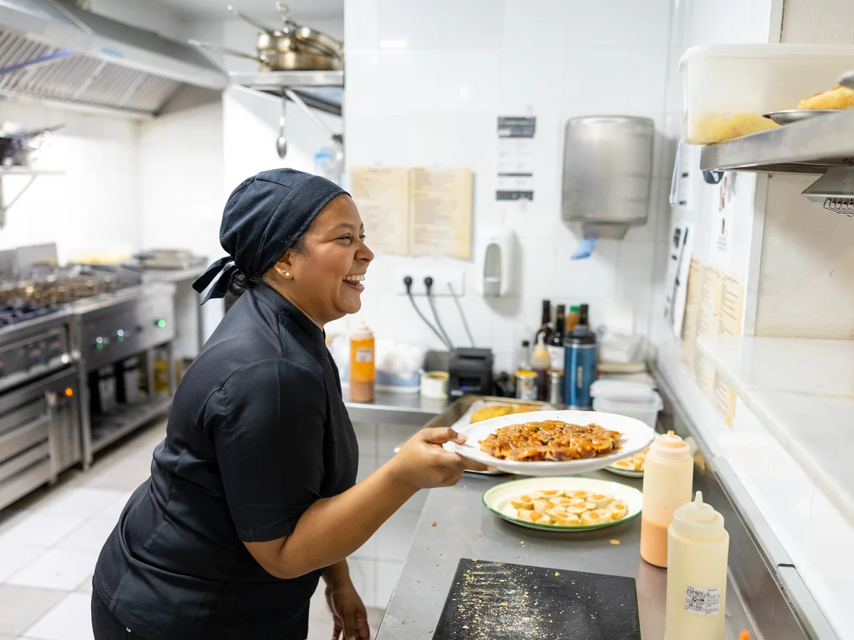 Cocinera de Casa Amparo sonriendo con un plato recién emplatado