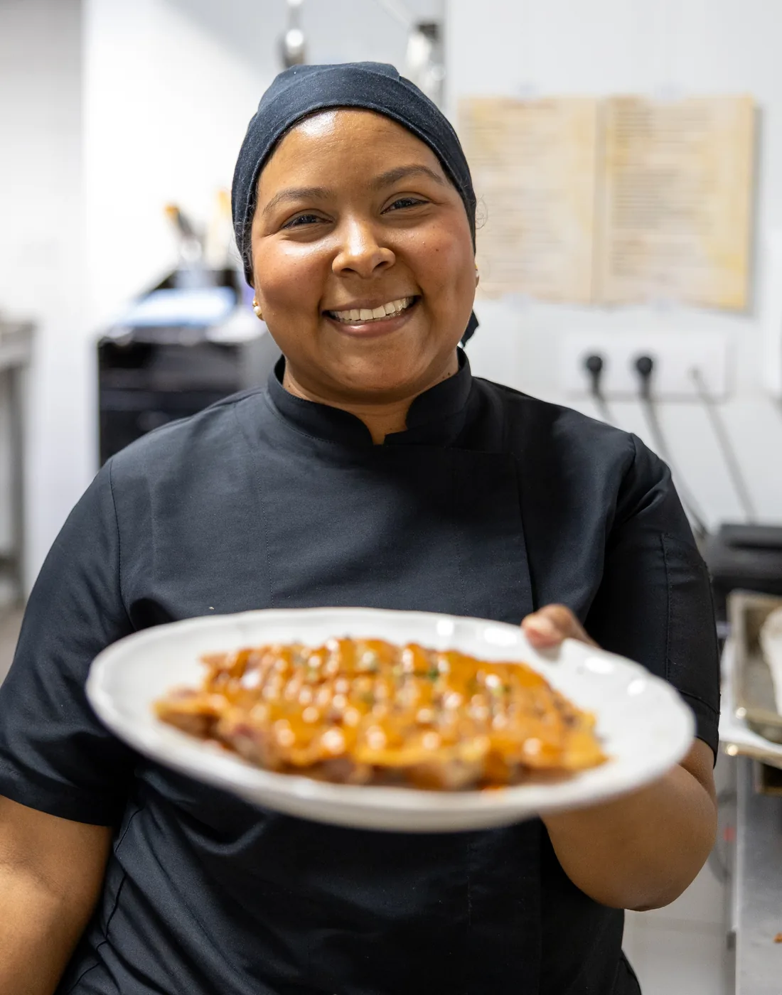 Cocinera de Casa Amparo emplatando un postre en cocina