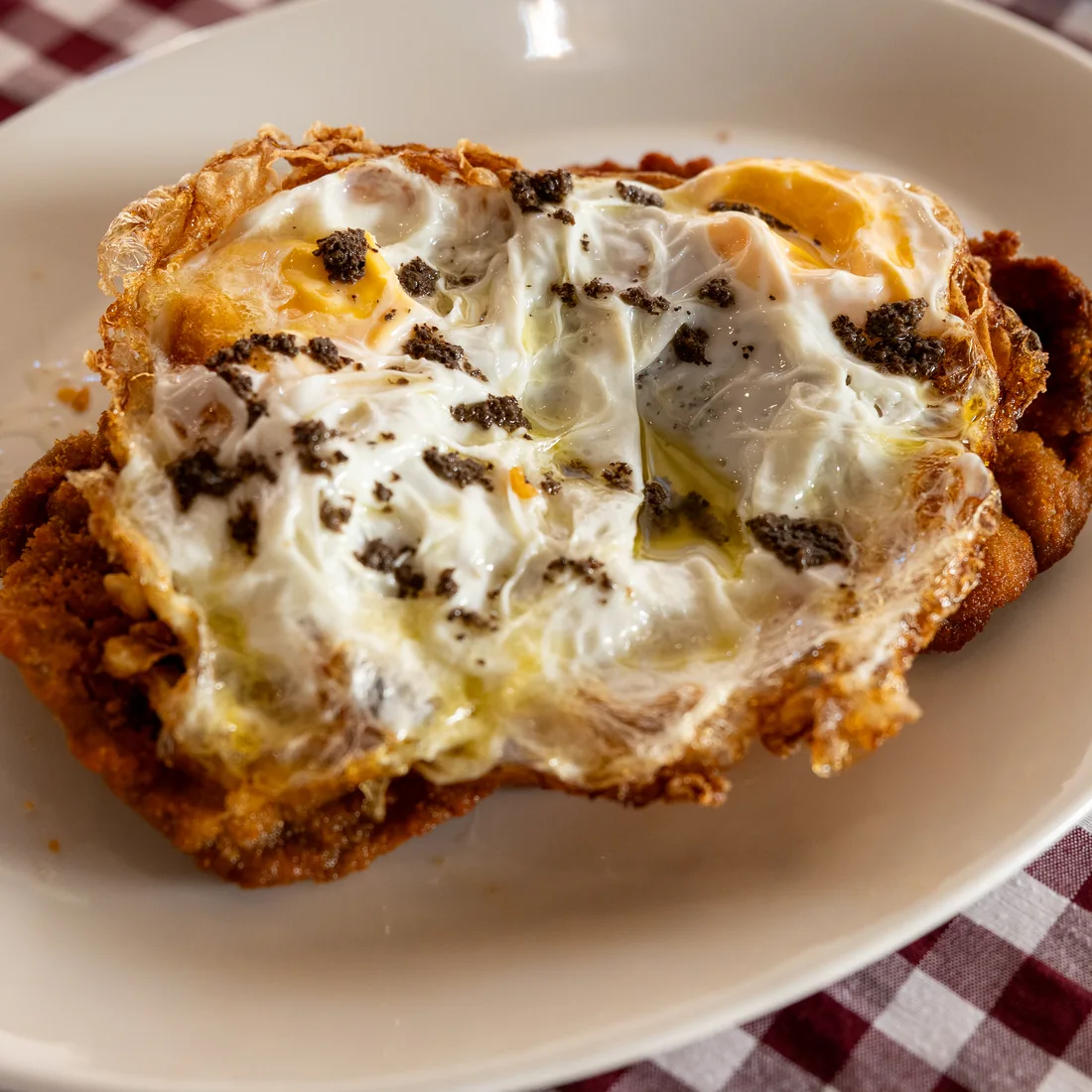 Huevos rotos con trufa negra rallada
