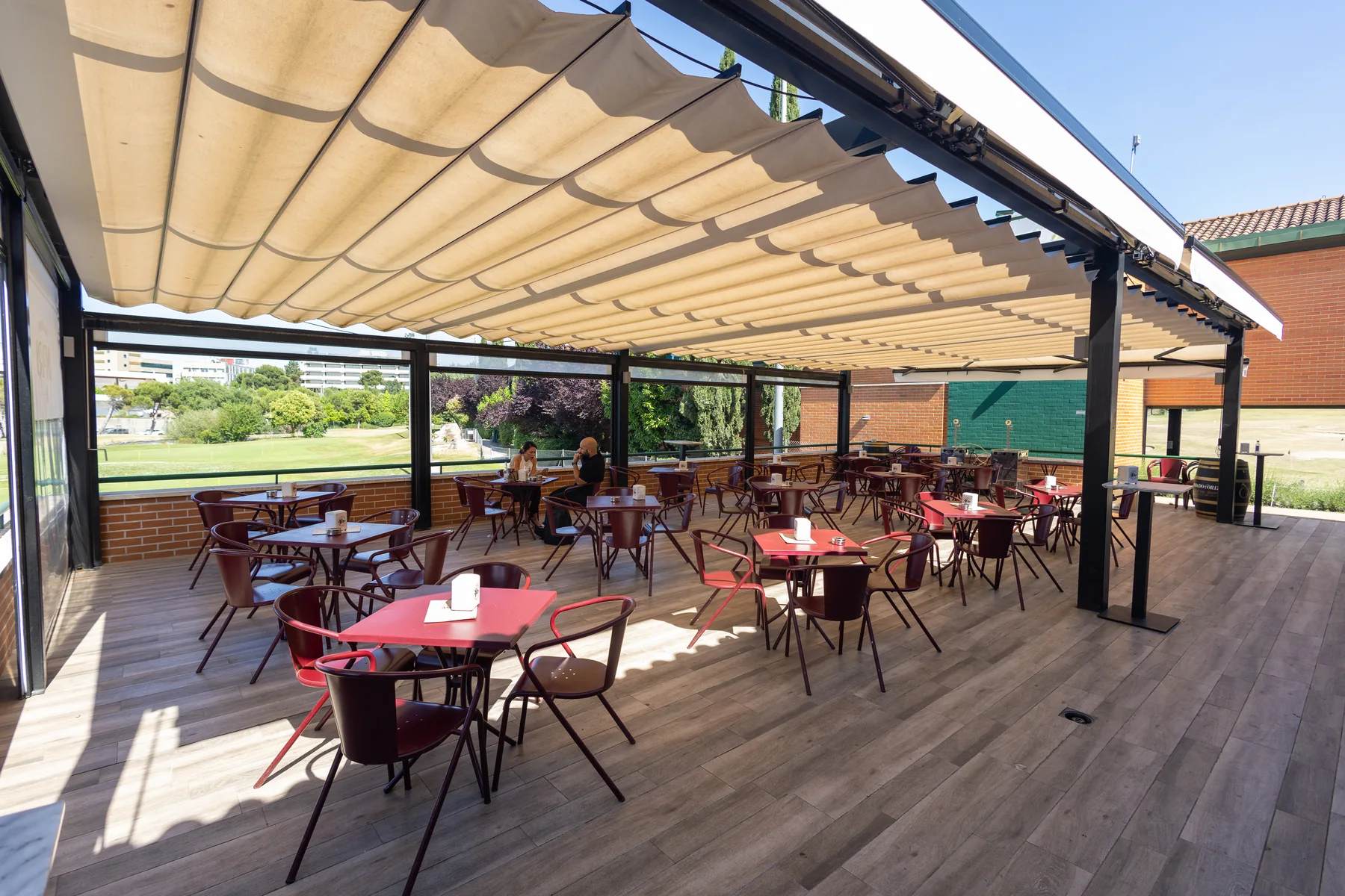 Terraza Golf de Casa Amparo cubierta con mesas y vistas al campo de prácticas
