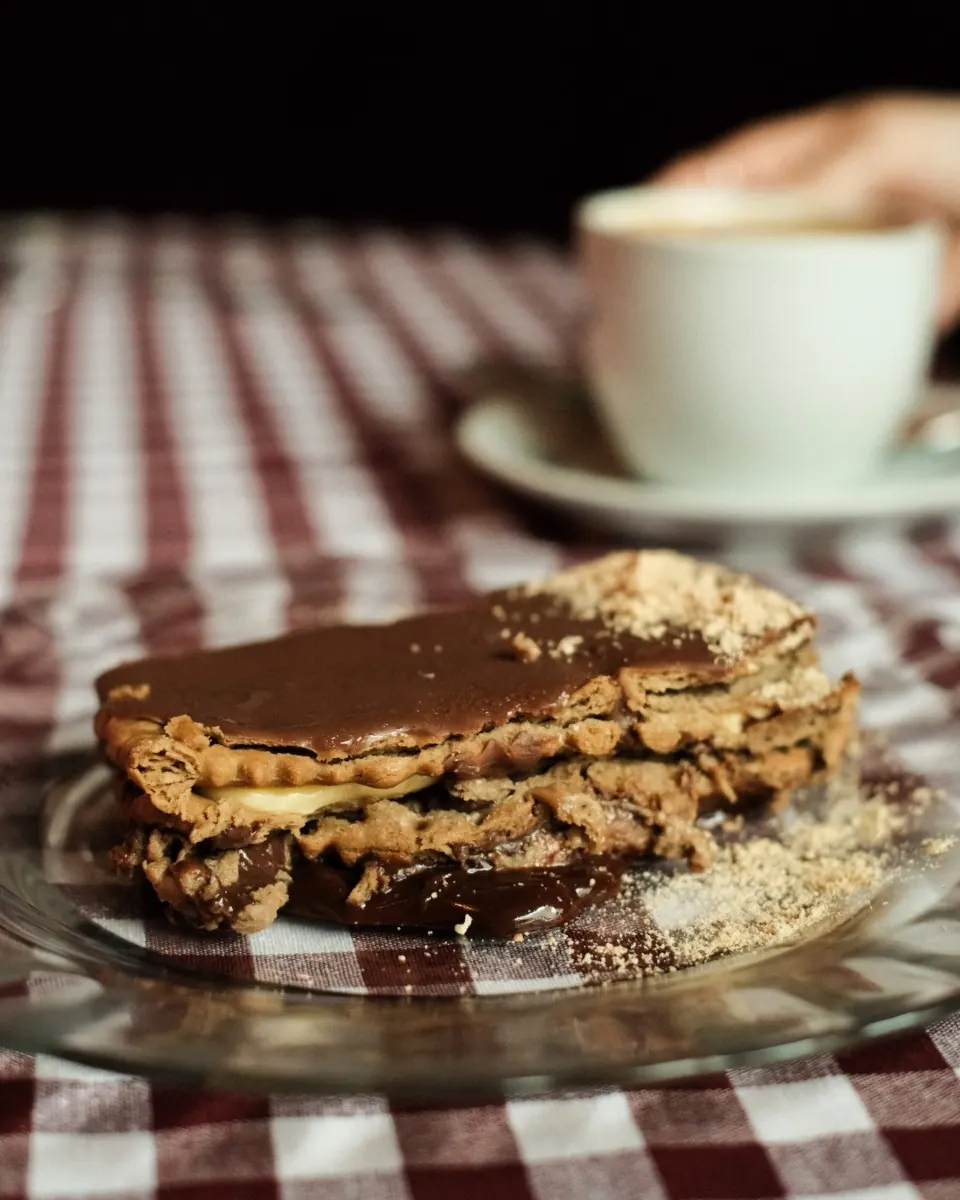 Torrija casera con crema y un café sobre mantel de cuadros