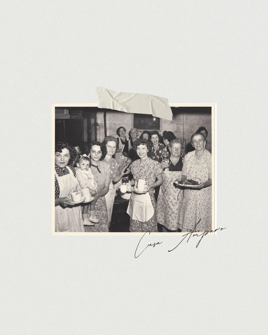Fotografía antigua de las mujeres de Casa Amparo, reunidas alrededor de la mesa